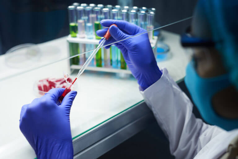 Female scientist sampling blood in test tubes in laboratory